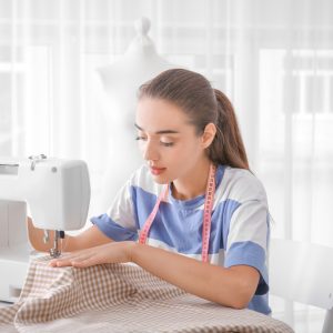 Beautiful young needlewoman in workshop