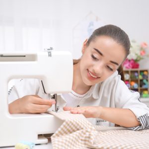 Beautiful young needlewoman in workshop